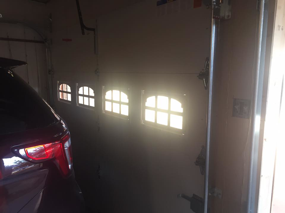 Interior view of a newly installed white garage door with windows by Big Red Overhead Door, LLC in Moore, OK.