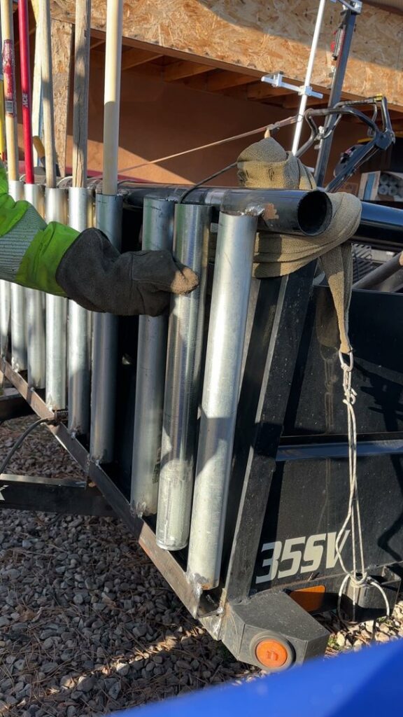 A person installing metal tubes for a custom tool rack on a trailer, a fabrication service by Jeremy's Welding & Handyman in West Jordan, UT.