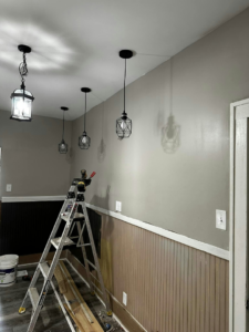 A ladder set up for installing new light fixtures in a hallway by Affordable Home Solutions in Springfield, PA.