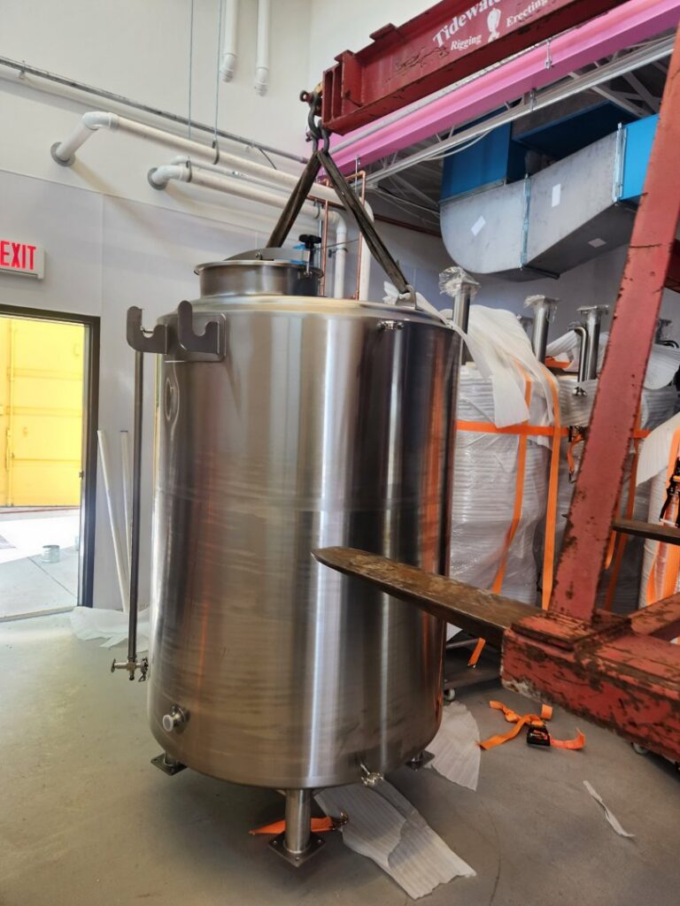 Tidewater Crane & Contracting installing a large stainless steel tank indoors in Virginia Beach, VA