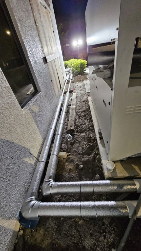 Insulated pipes being installed along the exterior of a building, a general contractor service by Belair Inc. in Saint Cloud, FL