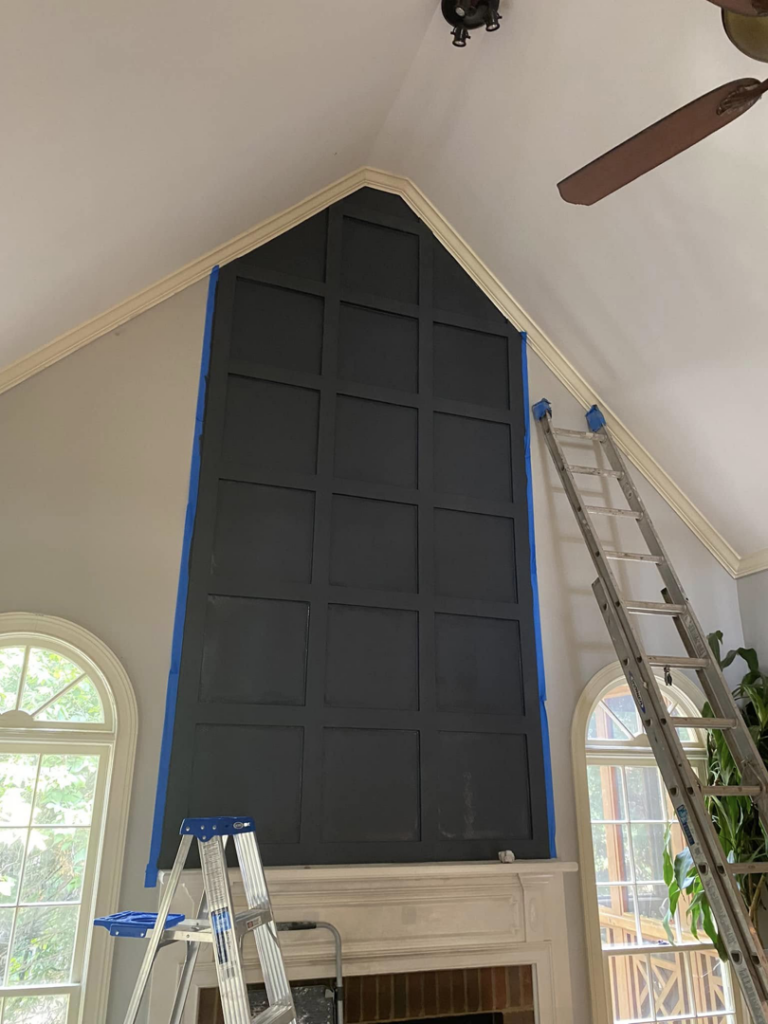 A tall paneled accent wall being painted dark grey during an interior renovation by Atlanta Handyman and Repair LLC in Johns Creek, GA.