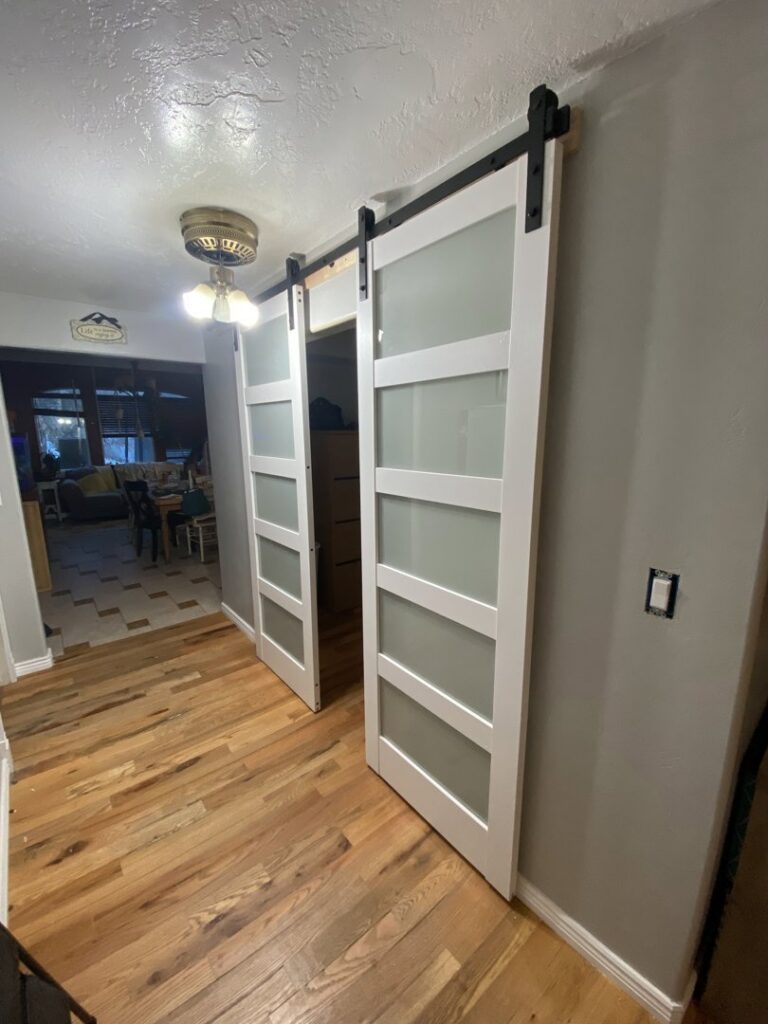 Newly installed interior barn doors with frosted glass panels, a home improvement service by No Delay SVCS in Pocatello, ID.