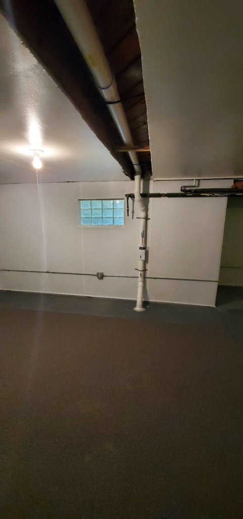 Interior view of a basement showing radon mitigation piping installed by All Ohio Radon Services in Akron, OH.