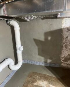 Newly installed interior basement waterproofing system with wall coating and drainage by Foundation Repair and Waterproofing in Philadelphia, PA.