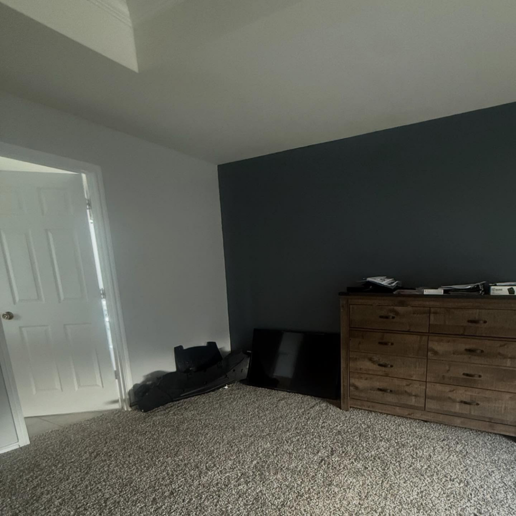 A freshly painted interior bedroom featuring a dark accent wall by The First Choice Painting in San Antonio, TX