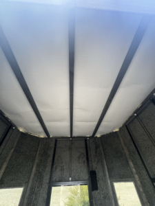 Interior view of a structure's ceiling showing insulation and support beams installed by JDM Outdoors of Robinson in Pittsburgh, PA.