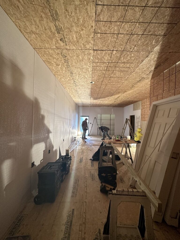 Interior construction with exposed wood ceiling and walls, workers present, by KG Handyman & Remodeling in Vilonia, AR.