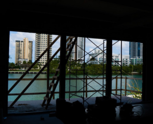 An interior view of a building under construction with scaffolding, overlooking the Miami skyline by Intelligent Construction Inc. in Miami, FL.