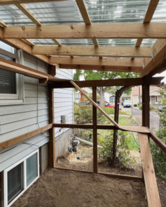 Interior view of a custom outdoor pet enclosure with a clear roof by Balance Painting & Remodeling, LLC in Portland, OR.