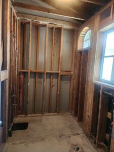 An interior room with exposed wooden framing after demolition by Impact Environmental Co. in El Cajon, CA.