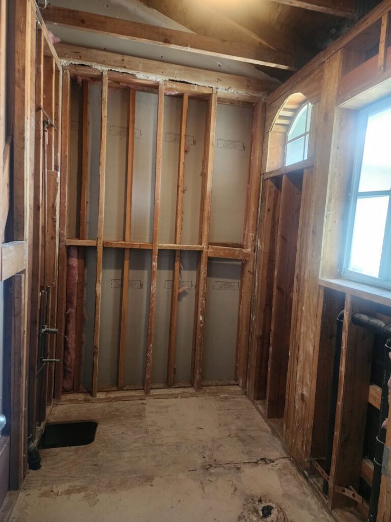 An interior room with exposed wooden framing after demolition by Impact Environmental Co. in El Cajon, CA.