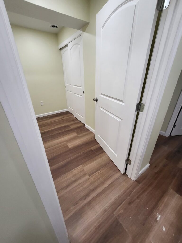 New interior doors and wood-look laminate flooring installed by Top Gunn Family Construction in Truxton, MO.