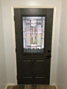 Interior dark wood door with decorative glass panel installed by Blue Heron Property Care LLC in Kalispell, MT