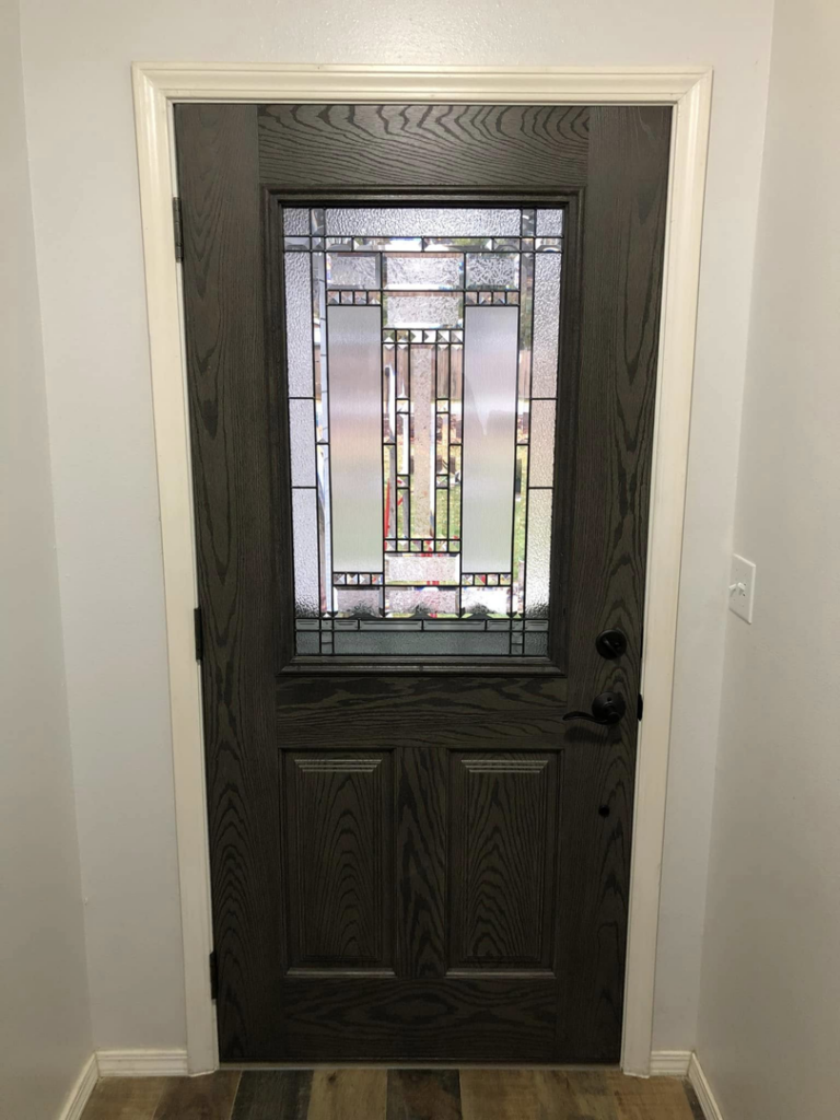 Interior dark wood door with decorative glass panel installed by Blue Heron Property Care LLC in Kalispell, MT