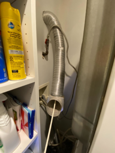 A handyman cleaning an interior dryer vent hose with a specialized tool for DiEduardo Home Services LLC in Edison, NJ.