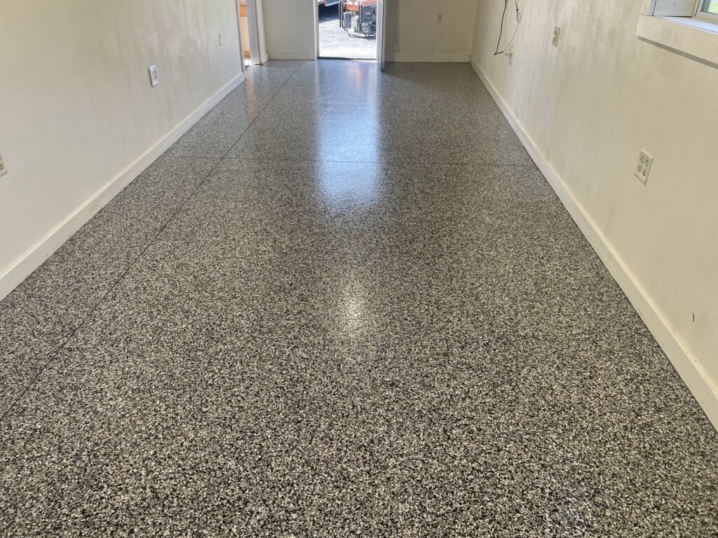 A long interior hallway with a new, durable floor coating installed by Egli Coating Solutions handyman in Evansville, IN.