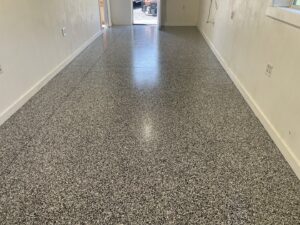 A long interior hallway with a new, durable floor coating installed by Egli Coating Solutions handyman in Evansville, IN.