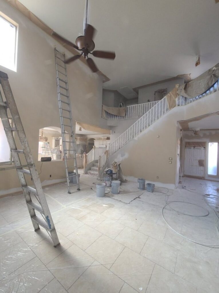 Interior of a house undergoing painting and renovation with ladders and supplies by Paint Co in Canyon Lake, CA