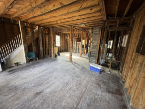 Interior view of a house during renovation, showing exposed wooden framing and subfloor by Staley Contracting in Richmond, VA