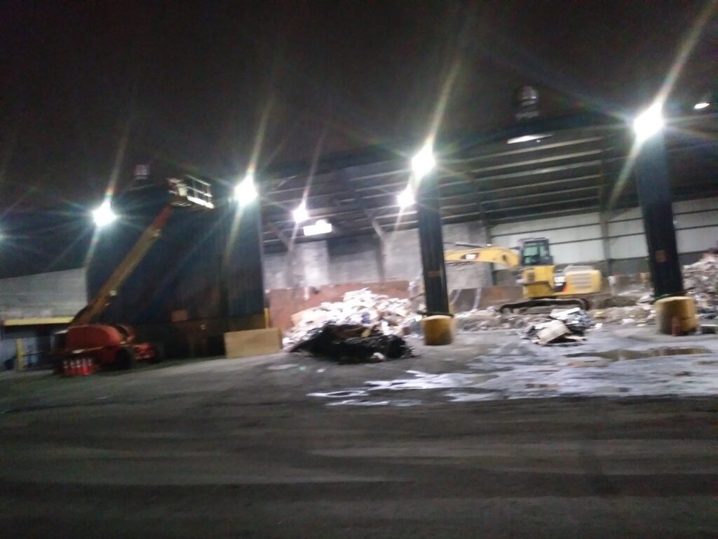 The interior of a junk processing plant with heavy machinery and waste piles, showcasing Lemcor's services in Newark, NJ.