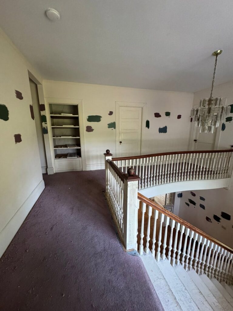 An interior space with paint swatches on the wall and a renovated staircase, indicating a painting project by Quinonez Painting & Renovations LLC in Providence, RI.