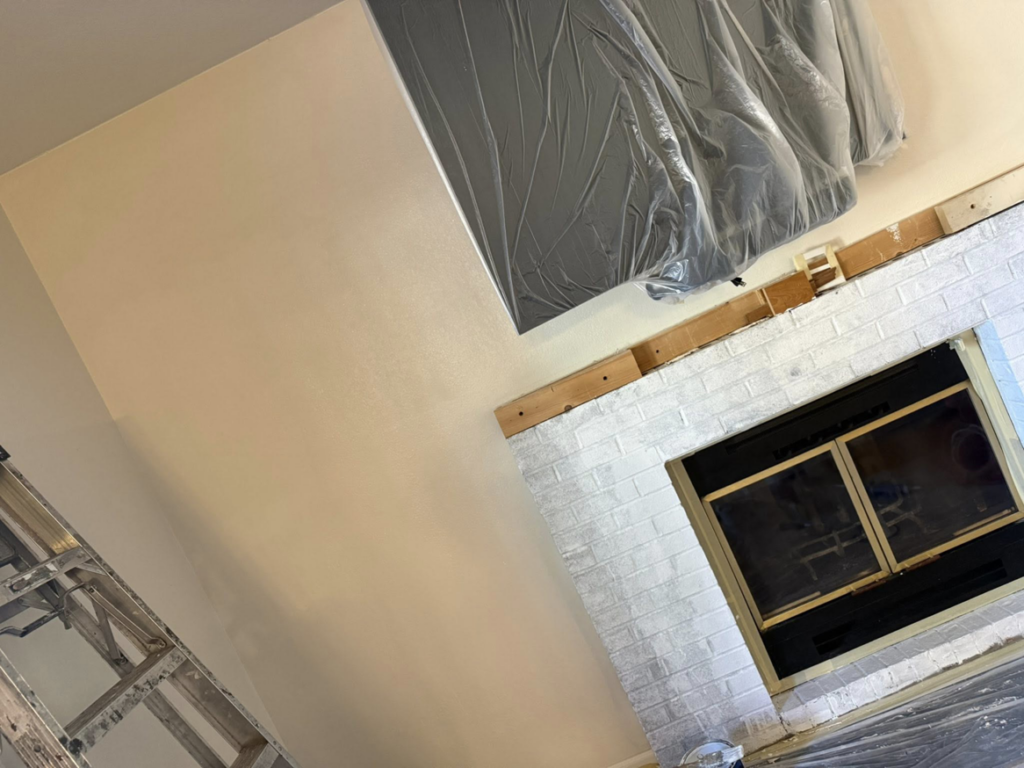 Interior wall painting and fireplace mantel installation in progress by Pineda's Construction LLC in Colorado Springs, CO