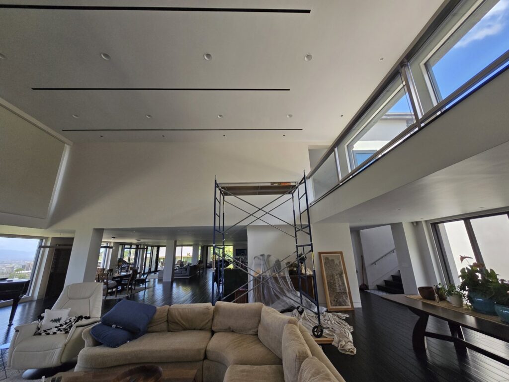 A spacious living room with scaffolding set up for interior painting or high-ceiling work by Just-In-Time Handyman Services in Honolulu, HI.