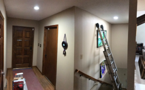 An interior hallway with a ladder, suggesting painting or light fixture installation by The Hot Handyman in Lawrence, KS.