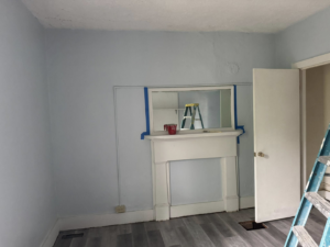 Interior painting preparation with blue painter's tape and a ladder in a room by JW Contracting Services, LLC in Dayton, OH.