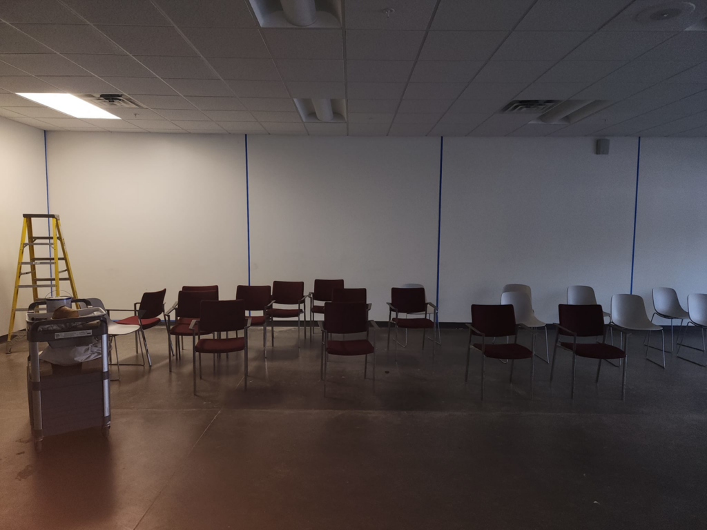 An interior room prepared for painting with blue painter's tape and a ladder, demonstrating handyman services by Reshaud Renovation LLC in Richmond, VA.