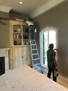 Two handymen from Spectrum Enterprises performing interior painting and trim work in a home in Baton Rouge, LA.
