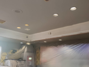 An interior room undergoing renovation with new recessed ceiling lighting and walls covered in plastic by RG Construction WA, LLC in Portland, OR.