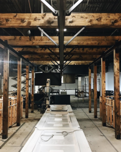 An interior renovation and construction site with exposed wooden beams and new doors ready for installation by BFC Construction in Tacoma, WA.