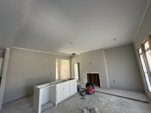 An interior room undergoing renovation with new drywall, cabinet bases, and a fireplace opening by JM Drywall LLC in Dothan, AL.