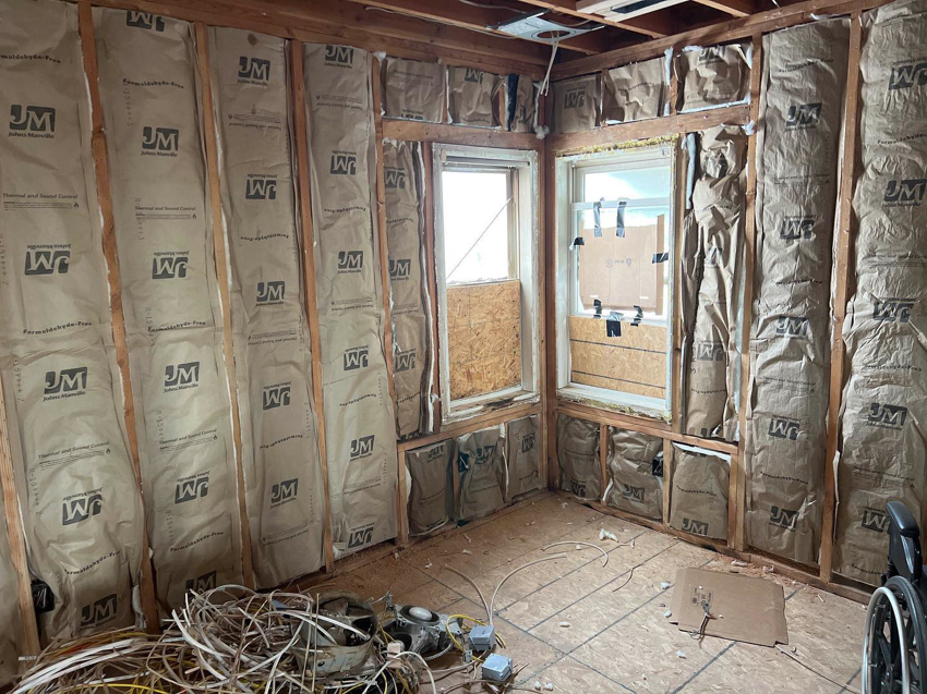 An interior renovation project featuring wall insulation, exposed studs, and electrical wiring by Kliesen Construction Company in Pueblo, CO.