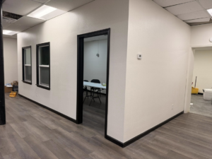 Newly renovated interior space with fresh paint, black trim, and new flooring by Yes Roofing & Construction Llc in Tulsa, OK.