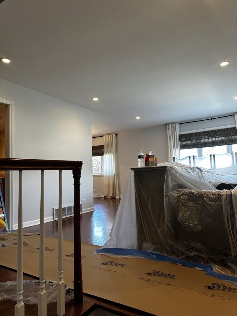 An interior space undergoing renovation, with furniture covered and new recessed lighting installed by Keeler Construction Group Inc. in Blue Island, IL.