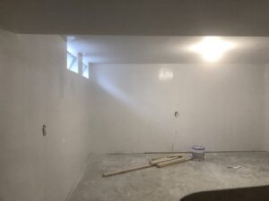 An interior room with freshly painted white walls and a paint bucket, indicating a painting service by Mp painting and roofing LLC in Dayton, OH