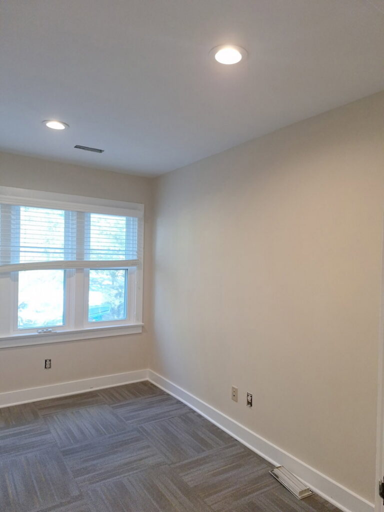 A freshly painted interior room with recessed lighting and a window by Albis Morales Painting LLC in Raleigh, NC.