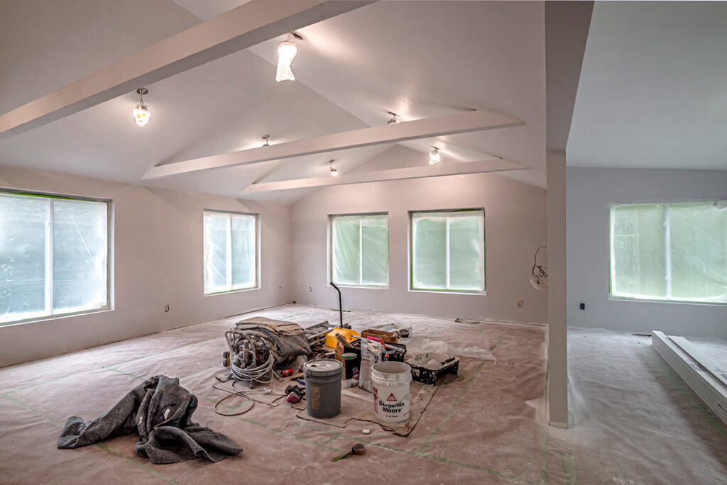 An interior room prepared for painting with drop cloths and equipment, showcasing GO Painting's work in New Haven, CT