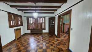 An interior room with wood paneling and flooring, showing freshly painted white walls by Acosta Painting LLC in Jonesboro, AR.