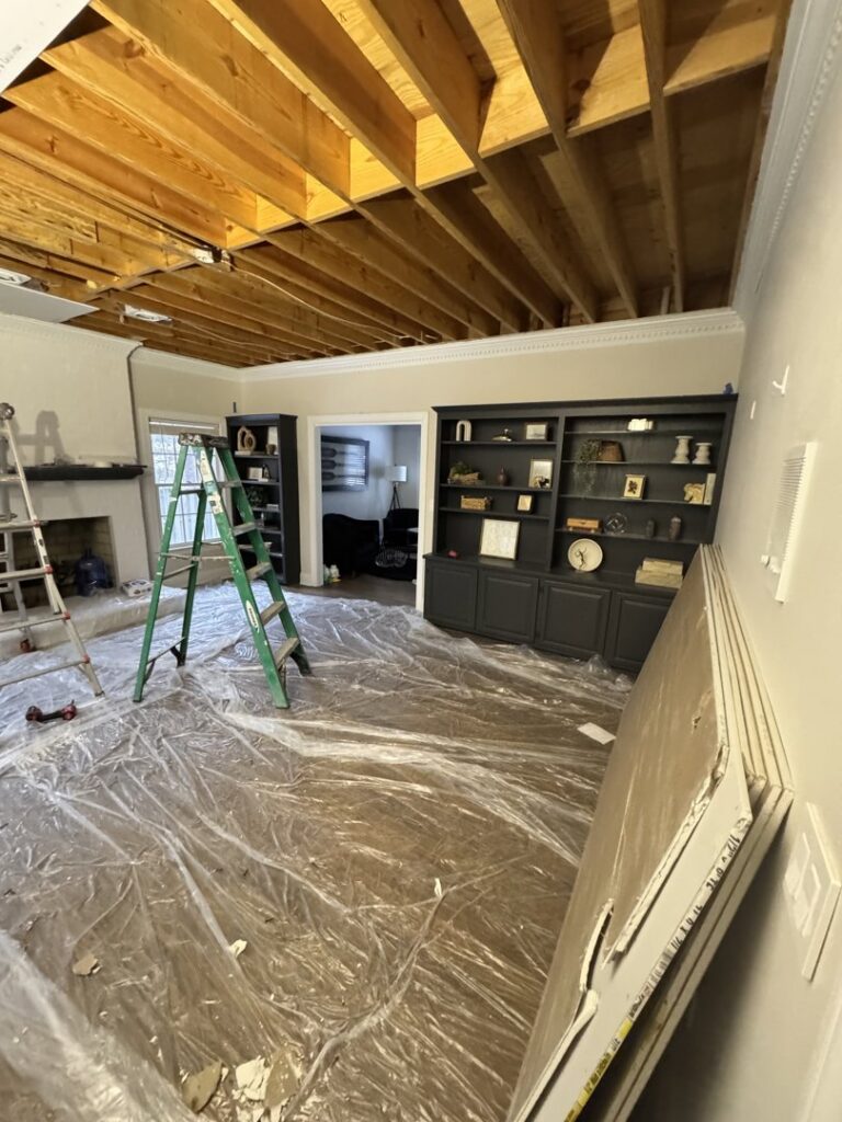 Interior room undergoing renovation with exposed ceiling joists and floor protection by Contractor Kev LLC in Winston-Salem, NC