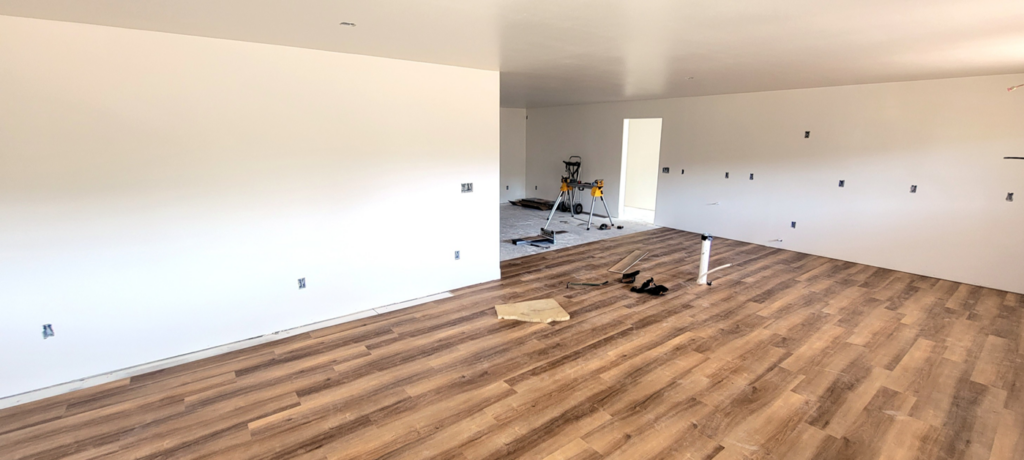 An interior room undergoing renovation with new flooring and freshly painted walls, showing ongoing work by Rapid Renovations LLC in Rapid City, SD.
