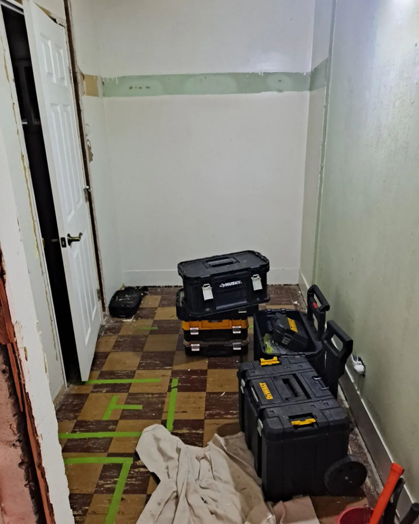 An interior room undergoing renovation, with handyman toolboxes and drop cloths on the floor by Honey Don'ts Handyman Service in Twin Falls, ID.