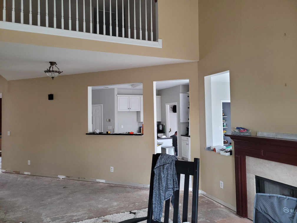 An interior room renovation in progress with exposed flooring and a fireplace by Housworth Construction in Suwanee, GA