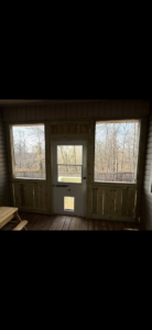 The interior of a newly built screened porch with wooden panels and a door, by Screw it, Call Rod in Rogers, AR.