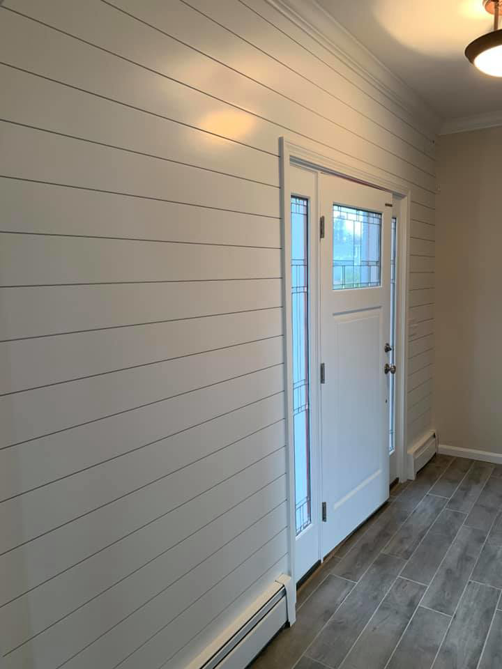 An interior wall featuring shiplap paneling and a newly installed door by D'Costa Finish Painting in Fall River, MA.