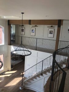 Modern black metal railings installed on an interior staircase and upper balcony by Custom Railing Solutions in Norfolk, VA