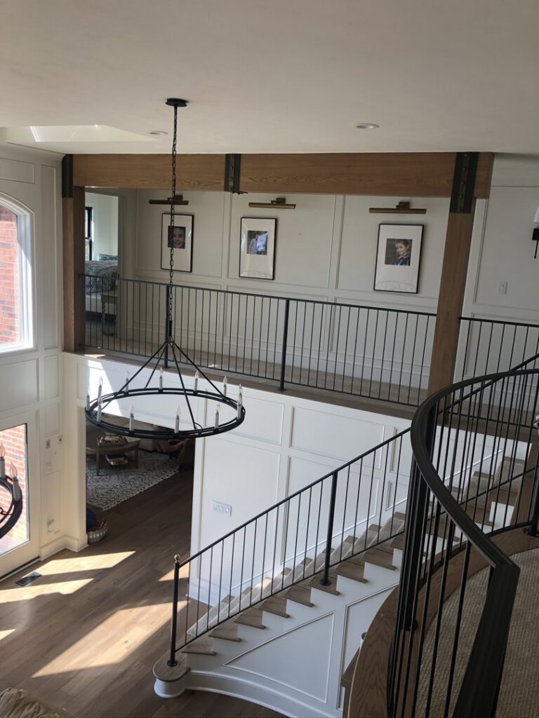 Modern black metal railings installed on an interior staircase and upper balcony by Custom Railing Solutions in Norfolk, VA